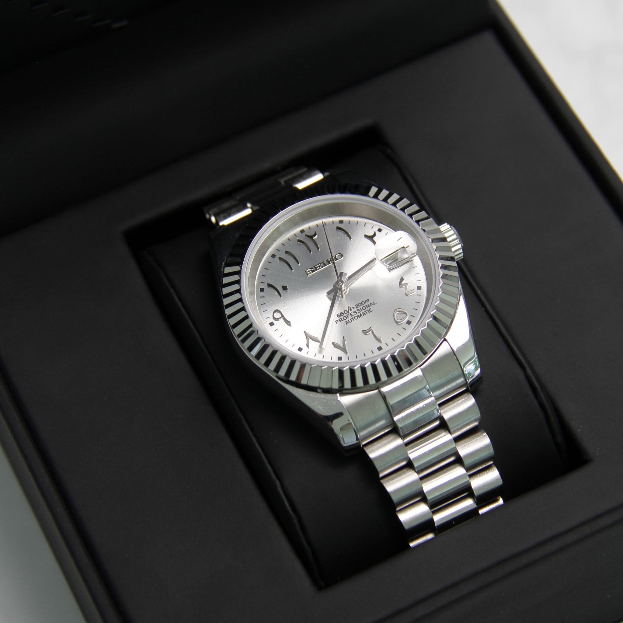 Montre Modus seiko datejust arabic gris argente sur coussin noir avec écrin Modus seiko