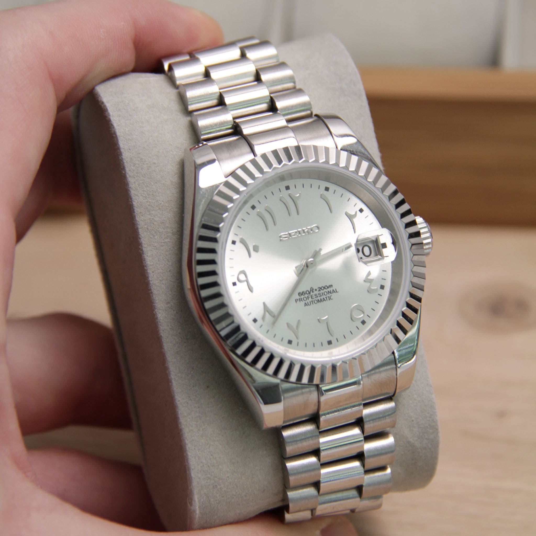 Montre Seiko mod datejust arabic gris argenté vu en gros plan sur coussin