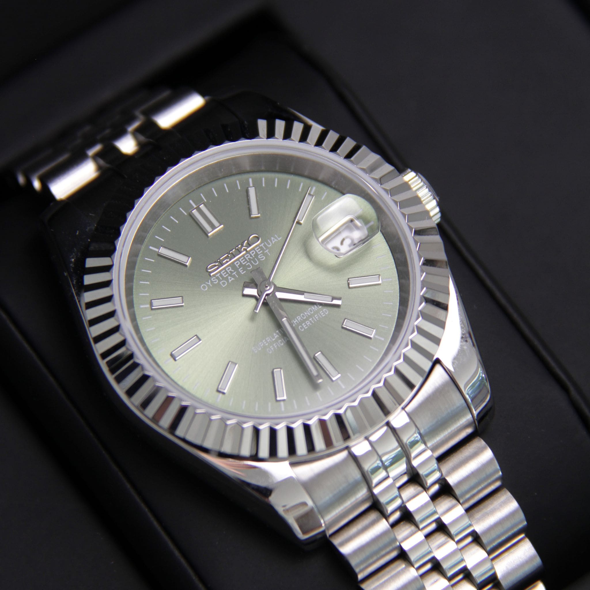 Montre Seiko mod datejust kaki arabic  vu de face sur coussin